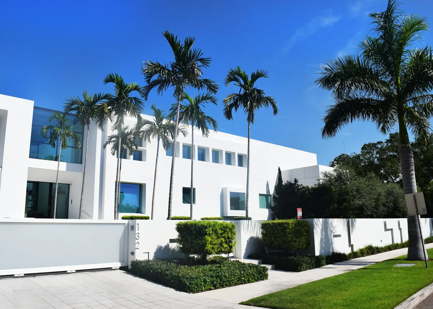 Modern white two-story Florida home with palm trees